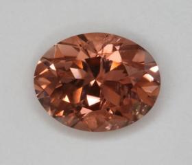 A modest, slightly included, pink, peach, golden oval.