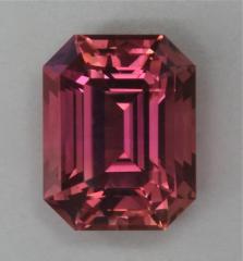 Full cut emerald cut with a great pink on the orange side.