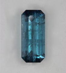 Heavily included blue emerald cut.