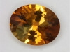 Modest golden tourmaline darkened with brown oval