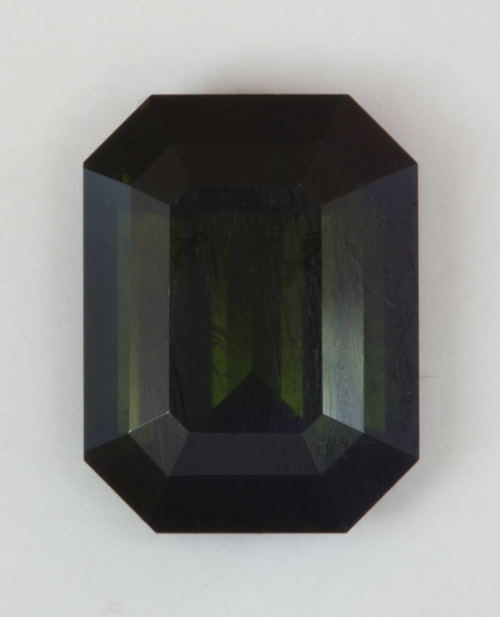 Dark dark green that looks black most of the time, emerald cut.