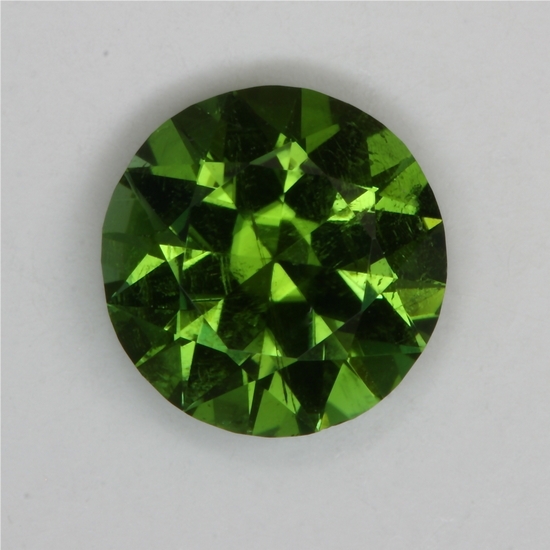 A medium toned, slightly included green, cuprian droplets of color.  #175