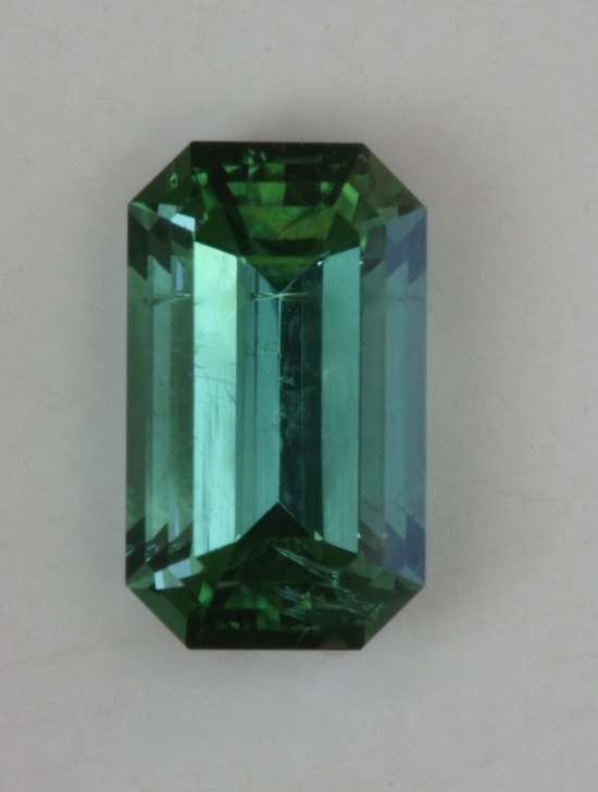 Bright, shifty, open, blue green emerald cut with significant flaw  #412.
