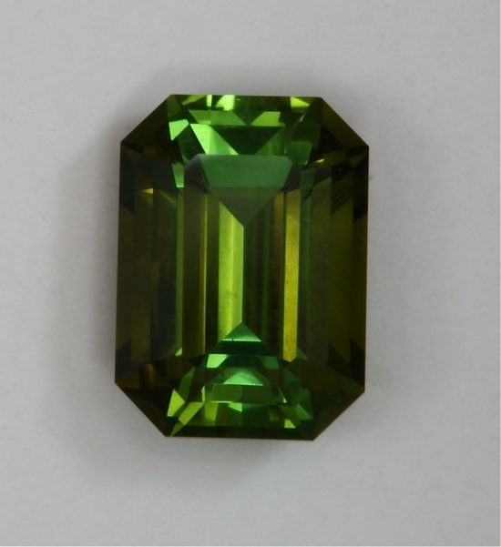 Bright completely open dichroic green and bronze emerald cut.  #417