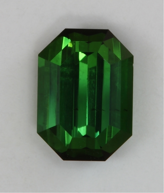Slightly included, medium dark toned, green emerald cut  #424